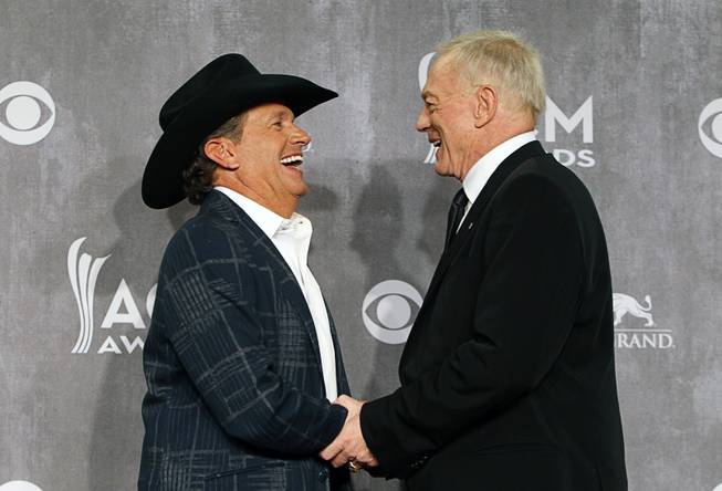 George Strait, Entertainer of the Year, greets Dallas Cowboys owner Jerry Jones in the photo room during the 49th Academy of Country Music Awards at the MGM Grand Garden Arena Sunday, April 6, 2014. The 2015 ACMA show will be held at the AT&T Stadium in Texas.