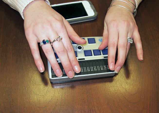 Megan Dausch, an instructor at the Helen Keller National Center, demonstrates the use of a Braille reader that helps blind clients access the Internet, in Sands Point, N.Y., March 26, 2014. 