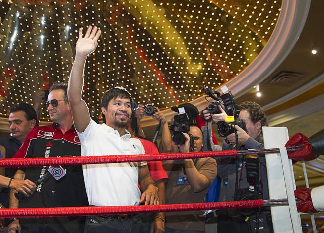 Boxer Manny Pacquiao of the Philippines waves to fans from a ring in the lobby of the MGM Grand Tuesday, April 8, 2014. Pacquiao will challenge undefeated WBO welterweight champion Timothy Bradley at the MGM Grand Garden Arena on Saturday. The fight is a rematch to a June 9, 2012 fight that Bradley won.