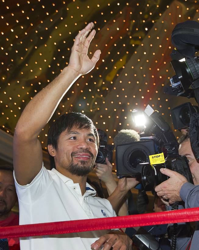 Boxer Manny Pacquiao of the Philippines waves to fans from a ring in the lobby of the MGM Grand Tuesday, April 8, 2014. Pacquiao will challenge undefeated WBO welterweight champion Timothy Bradley at the MGM Grand Garden Arena on Saturday. The fight is a rematch to a June 9, 2012 fight that Bradley won.