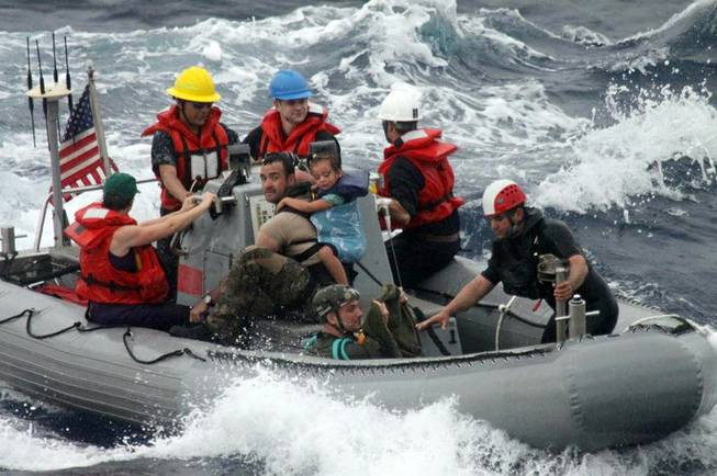 Sailors from Oliver Hazard Perry-class frigate USS Vandegrift (FFG 49) assist in the rescue of a family with a sick infant via the ship's small boat as part of a joint U.S. Navy, Coast Guard and California Air National Guard rescue effort, Sunday, April 6, 2014. 