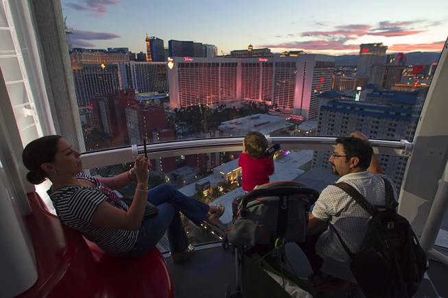 Carolina Higuera of Mexico takes a photo of her son Simon Torres, 20-months, and husband Leoncio Tores while riding the 550 foot-tall High Roller observation wheel, the tallest in the world, Wednesday, April 9, 2014. The wheel is the centerpiece of the $550 million Linq project, a retail, dining and entertainment district by Caesars Entertainment Corp.