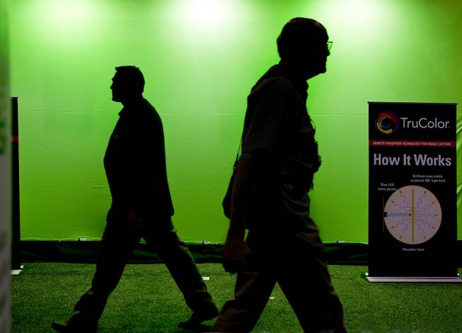 Attendees walk past a green screen offered by TruColor during the National Association of Broadcasters show at the Las Vegas Convention Center on Tuesday, April 8, 2014.