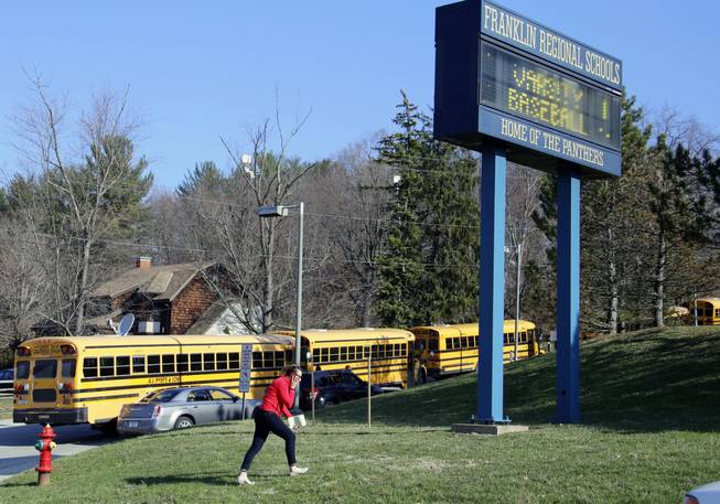 A woman walks onto the campus of the Franklin Regional School District where several people were stabbed at Franklin Regional High School on Wednesday, April 9, 2014, in Murrysville, Pa., near Pittsburgh. The suspect, a male student, was taken into custody and being questioned.