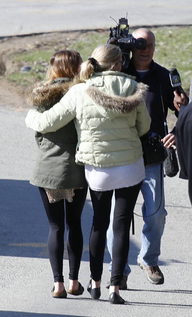 A pair of women walk arm-in-arm off the campus of the Franklin Regional School District, where several people were stabbed at Franklin Regional High School on Wednesday, April 9, 2014, in Murrysville, Pa., near Pittsburgh. The suspect, a male student, was taken into custody and being questioned.