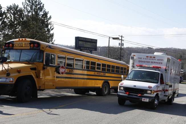 A Salvation Army disaster services vehicle drives past a school bus onto the campus of the Franklin Regional School District where several people were stabbed at Franklin Regional High School, Wednesday, April 9, 2014 in Murrysville, Pa., near Pittsburgh. The suspect, a male student, was taken into custody and being questioned.