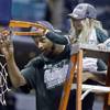 Michigan State forward Adreian Payne, left, cuts the net with Lacey Holsworth, who became close to Payne, after Michigan State defeated Michigan 69-55in the championship of the Big Ten Conference tournament on Sunday, March 16, 2014, in Indianapolis. Holsworth died of cancer on Tuesday, April 8, 2014, her family announced.
