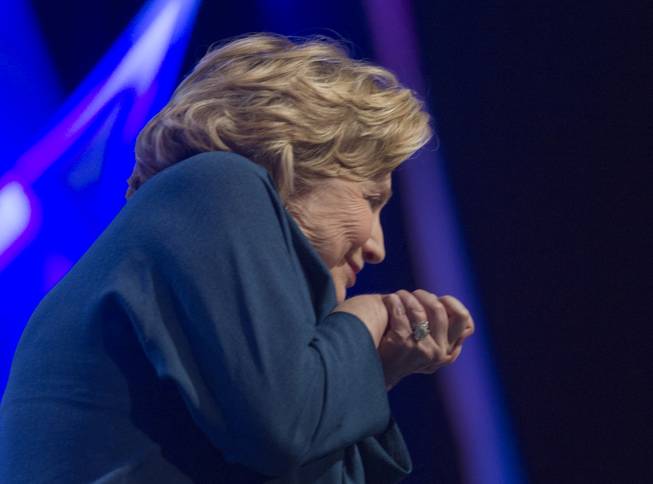 Former U.S. Secretary of State Hillary Rodham Clinton ducks as an object is thrown onstage during an address to members of the Institute of Scrap Recycling Industries during their annual convention Thursday, April 10, 2014, at Mandalay Bay Convention Center. 
