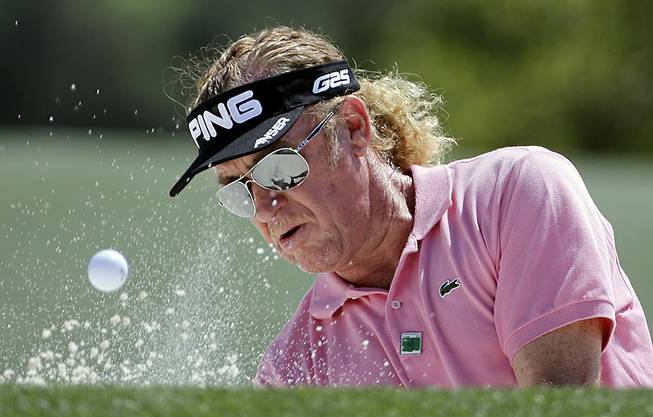 Miguel Angel Jimenez, of Spain, hits out of a bunker on the 18th hole during the first round of the Masters golf tournament Thursday, April 10, 2014, in Augusta, Ga. 