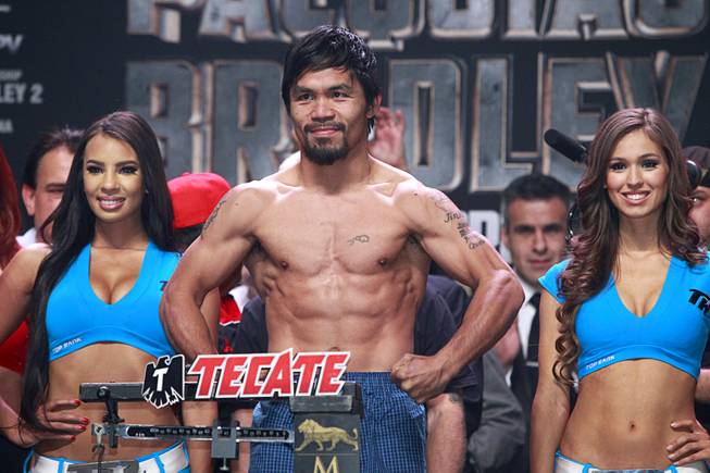 Boxer Manny Pacquiao of the Philippines shows off his physique during an official weigh-in at the MGM Grand Garden Arena Friday, April 11, 2014. Pacquiao will challenge undefeated WBO welterweight champion Timothy Bradley at the arena on Saturday. The fight is a rematch to a June 9, 2012 fight that Bradley won.