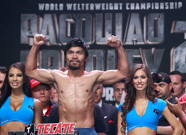 Boxer Manny Pacquiao of the Philippines poses on the scale during an official weigh-in at the MGM Grand Garden Arena Friday, April 11, 2014. Pacquiao will challenge undefeated WBO welterweight champion Timothy Bradley at the arena on Saturday. The fight is a rematch to a June 9, 2012 fight that Bradley won.