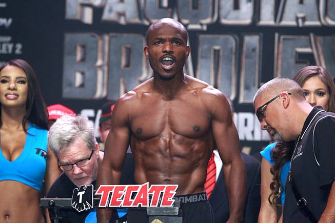Undefeated WBO welterweight champion Timothy Bradley stands on the scale during an official weigh-in at the MGM Grand Garden Arena Friday, April 11, 2014. Checking the weight is Manny Pacquiao trainer Freddie Roach (L) and Bradley trainer Joel Diaz (R). Bradley will defend his title against Manny Pacquiao of the Philippines at the arena on Saturday. The fight is a rematch to a June 9, 2012 fight that Bradley won.