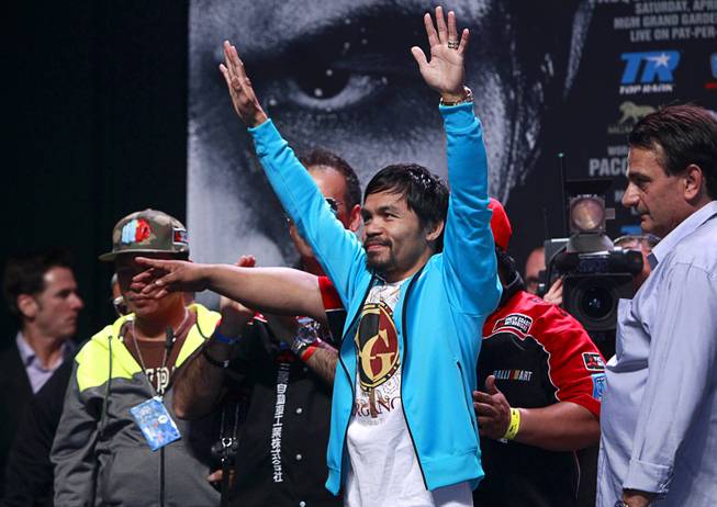 Boxer Manny Pacquiao of the Philippines acknowledges cheers from his fans during an official weigh-in at the MGM Grand Garden Arena Friday, April 11, 2014. Pacquiao will challenge undefeated WBO welterweight champion Timothy Bradley at the arena on Saturday. The fight is a rematch to a June 9, 2012 fight that Bradley won.