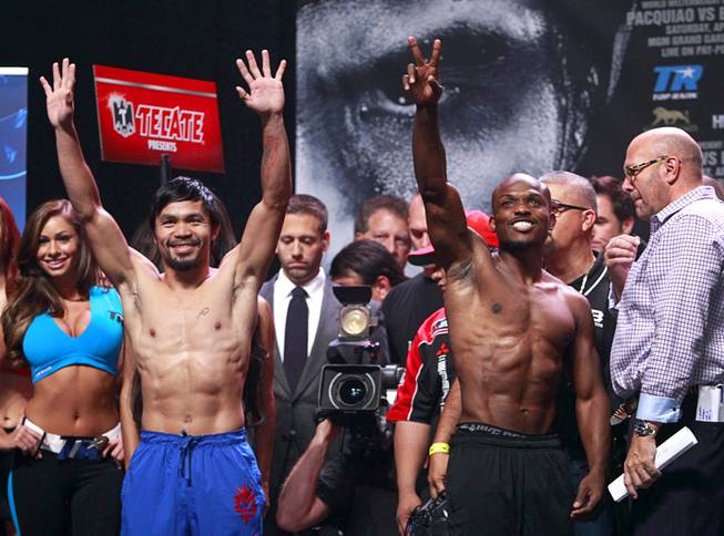 Boxer Manny Pacquiao, left, of the Philippines and undefeated WBO welterweight champion Timothy Bradley wave to fans during an official weigh-in at the MGM Grand Garden Arena Friday, April 11, 2014. Pacquiao will challenge Bradley at the arena on Saturday. The fight is a rematch to a June 9, 2012 fight that Bradley won.