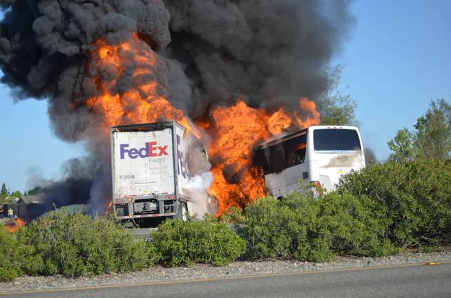 Massive flames are seen devouring both vehicles just after the crash, and clouds of smoke billowed into the sky Thursday April 10, 2014, until firefighters had quenched the fire, leaving behind scorched black hulks of metal. The FedEx tractor-trailer crossed a grassy freeway median in Northern California and slammed into the bus carrying high school students on a visit to a college.