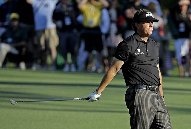 Phil Mickelson reacts after putting his third shot into the water on the 15th hole during the first round of the Masters on Thursday, April 10, 2014, in Augusta, Ga.