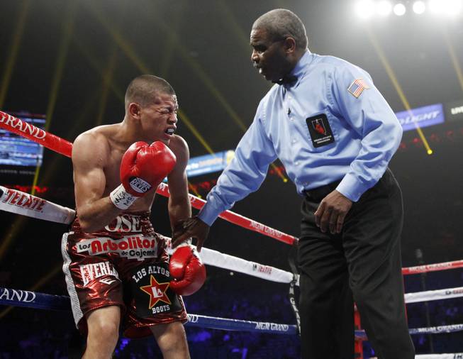 Referee Robert Byrd checks Jose Felix, who winces as a welt develops after an accidental head butt from Bryan Vazquez during their WBA interim super featherweight fight at the MGM Grand Garden Arena on Saturday, April 12, 2014.