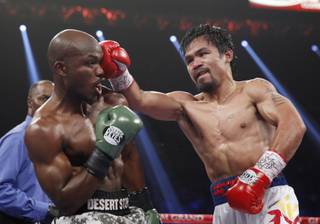 Manny Pacquiao hits undefeated WBO welterweight champion Timothy Bradley with a right during their title fight at the MGM Grand Garden Arena on Saturday, April 12, 2014.