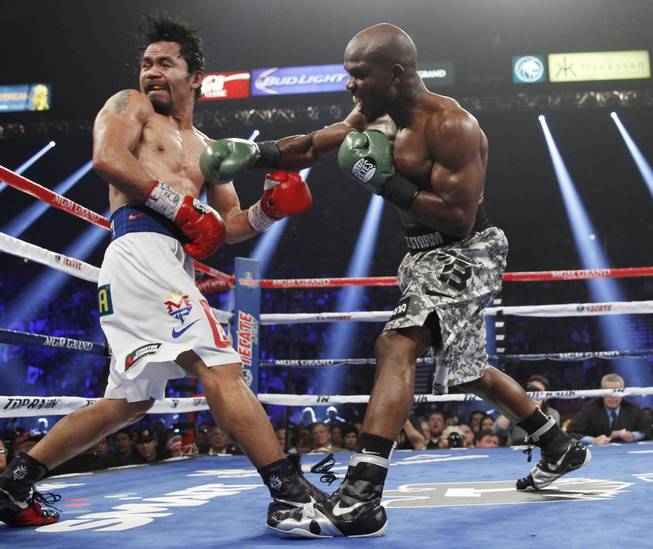 Manny Pacquiao is hit with a right from undefeated WBO welterweight champion Timothy Bradley during their title fight at the MGM Grand Garden Arena on Saturday, April 12, 2014.