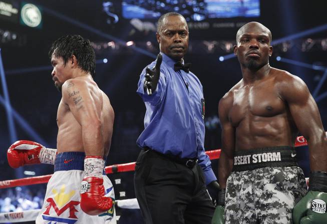 Referee Kenny Bayless separates Manny Pacquiao, left, and undefeated WBO welterweight champion Timothy Bradley at the end of a round of their title fight at the MGM Grand Garden Arena on Saturday, April 12, 2014. Pacquiao won by unanimous decision.
