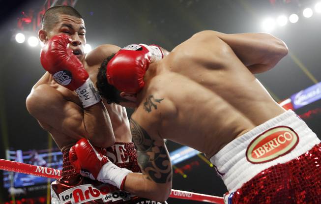 Jose Felix (left) of Mexico is hit with a left by Bryan Vazquez of Costa Rica during their WBA interim super featherweight fight at the MGM Grand Garden Arena on Saturday, April 12, 2014.