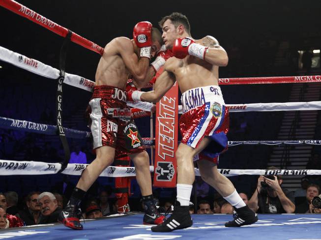 Jose Felix (left) of Mexico is hit by a right from Bryan Vazquez of Costa Rica during their WBA interim super featherweight fight at the MGM Grand Garden Arena on Saturday, April 12, 2014.
