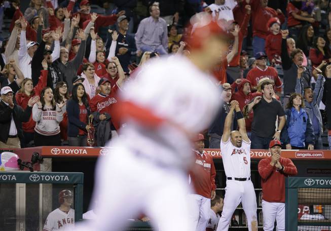Fans and Albert Pujols cheer as Los Angeles Angels' Raul Ibanez, foreground, rounds the bases after hitting a three-run home run during the ninth inning of a baseball game against the New York Mets on Saturday, April 12, 2014, in Anaheim, Calif.
