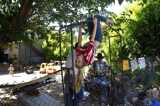 Jerusha Bundy, 10, plays on a gate at the family ranch near Bunkerville Sunday, April 13, 2014. The Bureau of Land Management halted their roundup of Bundy family cattle under an agreement reached Saturday.
