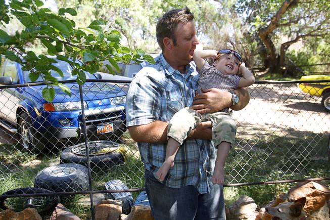 Dave Bundy, one of Cliven Bundy's son's, holds his son Payten, 18-months, at the family ranch near Bunkerville Sunday, April 13, 2014. The BLM halted their roundup of Bundy family cattle under an agreement reached Saturday.