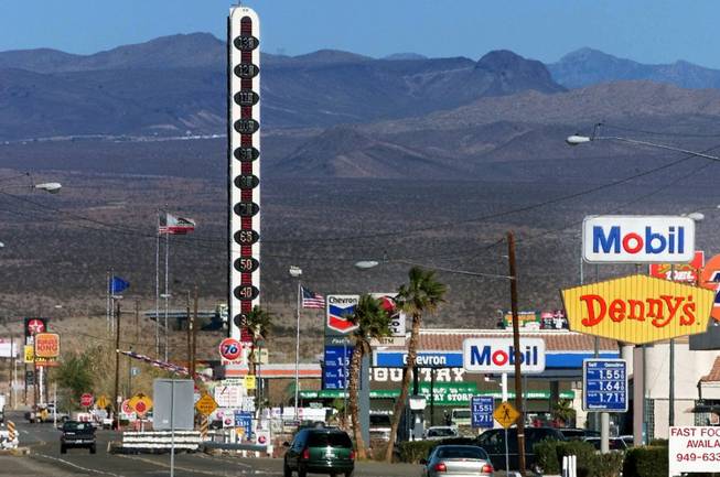 This Jan. 27, 2000, file photo shows visitors driving through the town of Baker, Calif., as the world's tallest thermometer stands in the background.
