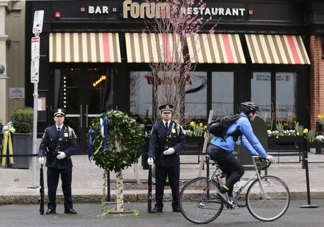 A Boston Police honor guard is posted outside the Forum restaurant, the site of the second of two bombs that exploded near the finish line of the 2013 Boston Marathon, Tuesday, April 15, 2014 in Boston. Three were killed and more than 260 injured in last year's explosions near the finish line of the race.
