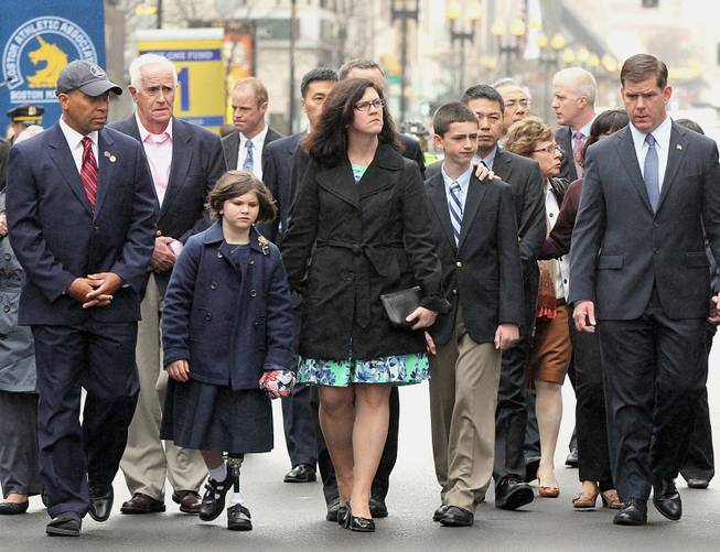 Family members of marathon bombing victims, Martin Richard, Krystle Campbell and Lu Lingzi are joined by Massachusetts Gov. Deval Patrick, left, and Boston Mayor Martin Walsh, right, during a wreath laying ceremony to commemorate the one year anniversary of the Boston Marathon bombings, Tuesday, April 15, 2014, in Boston. (AP Photo/The Boston Globe, Wendy Maeda)  BOSTON HERALD OUT, QUINCY OUT; NO SALES