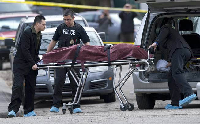 Police remove a body from the scene of a multiple fatal stabbing in northwest Calgary, Alberta, Tuesday, April 15, 2014. Police say five people are dead after the stabbing at a house party. 