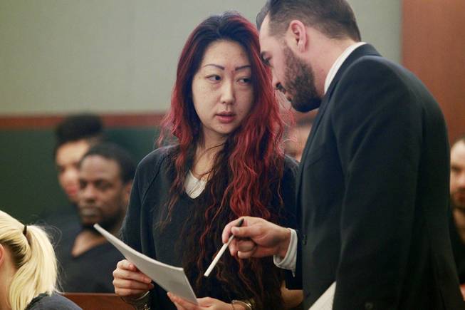 Gloria Lee speaks with attorney Dustin Marcello as she appears in Clark County District Court for her arraignment on charges stemming from an arson fire at Lee's pet store Wednesday, April 16, 2014.