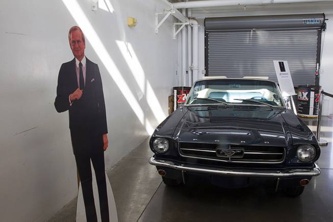 A cardboard cutout of automotive executive Lee Iacocca is shown by his 1965 Mustang convertible during the Mustang 50th Birthday Celebration at the Las Vegas Motor Speedway Thursday April 17, 2014. Iacocca participated in the design of the Ford Mustang and other successful Ford models before joining Chrysler.