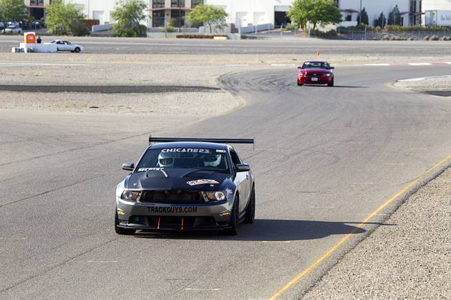Late-model Mustangs are driven on a road course during the Mustang 50th Birthday Celebration at the Las Vegas Motor Speedway Thursday April 17, 2014.