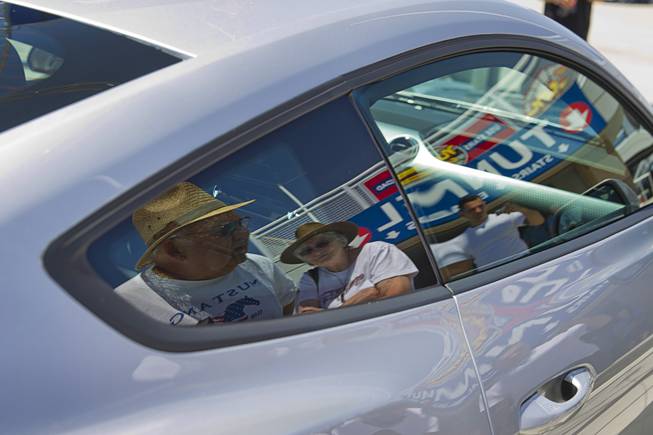 Jim Ramsden and his wife nancy of Salem, Oregon, are reflected in the window of a 2015 Ford Mustang during the Mustang 50th Birthday Celebration at the Las Vegas Motor Speedway Thursday, April 17, 2014. The celebration continues through Sunday.