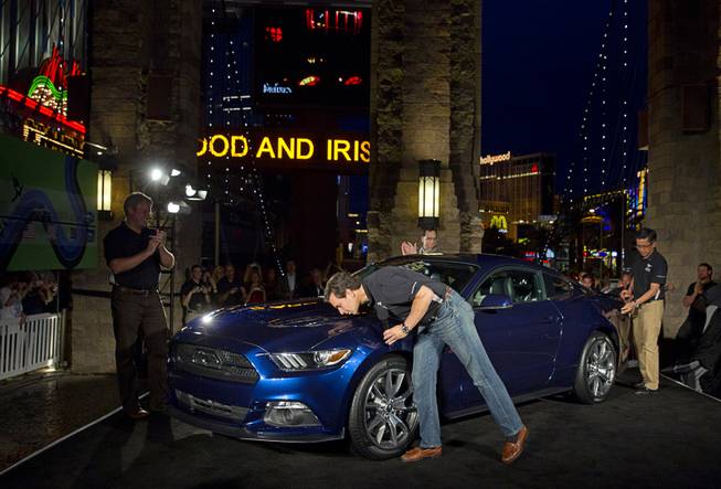 Mark Fields, chief operating officer for Ford Motor Company, kisses a 2015 50 Year Limited Edition Mustang in front of the New York-New York Thursday April 17, 2014. The unveiling was part of the Mustang 50th Birthday Celebration taking place at the Las Vegas Motor Speedway. Ford announced that they will build 1,964 of the 50-Year Limited Edition model.