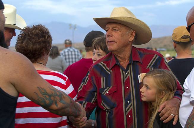 Rancher Cliven Bundy greets supporters during a Bundy family "Patriot Party" near Bunkerville Friday, April 18, 2014. His granddaughter Jerusha Bundy, 10, is at right. The family organized the party to thank people who supported Bundy in his dispute with the Bureau of Land Management.