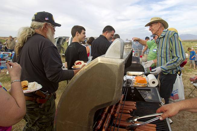 Vinayak (no other name provided), right, works a food line during a Bundy family "Patriot Party" near Bunkerville Friday, April 18, 2014. The family organized the party to thank people who supported rancher Cliven Bundy in his dispute with the Bureau of Land Management.