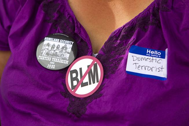 A woman wears a "No BLM" button during a Bundy family "Patriot Party" near Bunkerville Friday, April 18, 2014. The family organized the party to thank people who supported rancher Cliven Bundy in his dispute with the Bureau of Land Management.