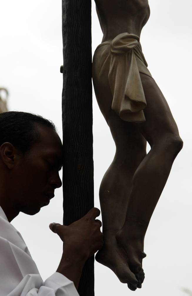 An altar boy carry a statue of Jesus Christ during a Good Friday procession in Panama City, Friday, April 18, 2014. Holy Week commemorates the last week of the earthly life of Jesus Christ culminating in his crucifixion on Good Friday and his resurrection on Easter Sunday. 