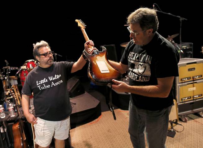 Guitar technician Vinnie Garcia hands Country legend Vince Gill his 1957 Fender Stratocaster after a sound check at the Mesa Performing Arts Center, in Mesa, Ariz. on Thursday, Oct. 24, 2013. Garcia, who has been best friends with Gill since the seventh grade, sold Gill his first Stratocaster for $200 and a pair of cowboy boots. Gill says, "I love the versatility of the guitar as much as anything, no matter what way you want to try to play it, it always responds."