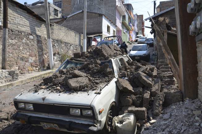 A parked car suffered damage when a adobe wall collapsed on it after a strong earthquake shook Chilpancingo, Mexico, Friday morning, April 18, 2014. A powerful magnitude-7.2 earthquake shook central and southern Mexico but there were no early reports of major damage or casualties.