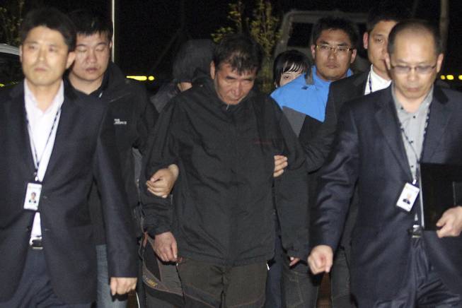 Lee Joon-seok, center, the captain of the sunken ferry Sewol in the water off the southern coast, arrives at a court which issues his arrest warrant in Mokpo, south of Seoul, South Korea, Friday, April 18, 2014. 