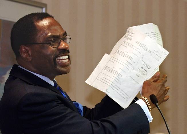 In this Jan. 29, 2004, file photo, former boxer Rubin "Hurricane" Carter holds up the writ of habeas corpus that freed him from prison during a news conference held in Sacramento, Calif. Carter, who spent almost 20 years in jail after twice being convicted of a triple murder he denied committing, died at his home in Toronto, Sunday, April 20, 2014, according to long-time friend and co-accused John Artis. He was 76.