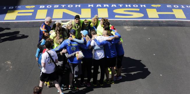Boston Marathon bombing survivors, family and friends gather in circle after crossing the finish line of the marathon during a Tribute Run, Saturday, April 19, 2014, in Boston. The 118th Boston Marathon is scheduled to run on Patriots Day, Monday, April 21. 