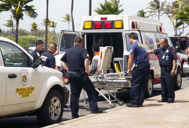A 16-year-old boy who stowed away in the wheel well of a flight from San Jose, Calif., to Maui, on stretcher at center, is loaded into an ambulance at Kahului Airport in Kahului, Maui, Hawaii Sunday afternoon, April 20, 2014. Officials say the boy is "lucky to be alive" and unharmed, surviving cold temperatures at 38,000 feet and a lack of oxygen.