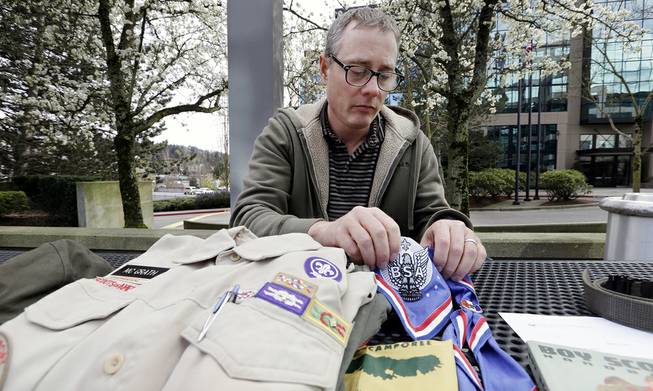 Geoff McGrath displays a vintage Boy Scout Handbook given him as a gift by one of the boys in the Seattle troop he led in Bellevue, Wash., April 1, 2014. 