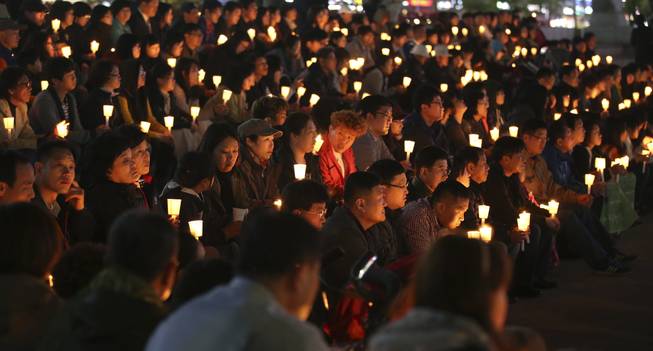South Koreans hold candles during a prayer for people believed to have been trapped in the sunken ferry Sewol, in Ansan, South Korea, Monday, April 21, 2014.